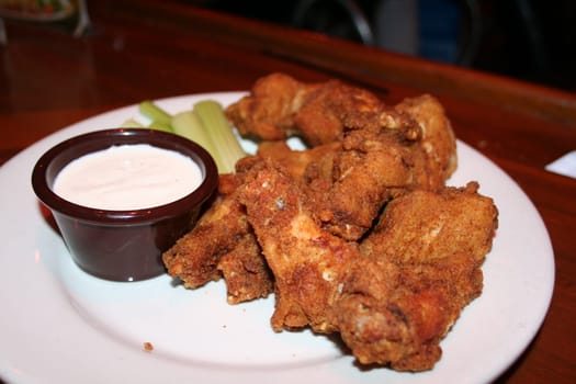 plate of chicken wings, celery, and tanch dressing