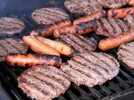 Hamburger and hot dogs being grilled.