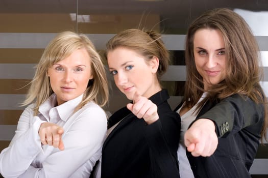 Three young professionals pointing their finger at...