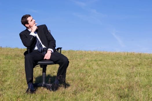 Young businessman on the meadow