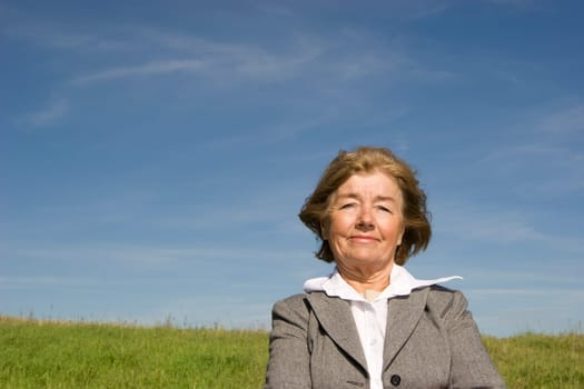 Beautiful, joyful mature woman on the meadow