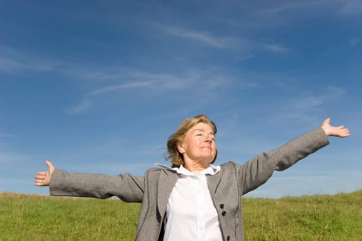 Beautiful, joyful mature woman on the meadow