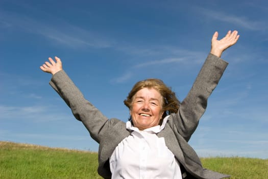 Beautiful, joyful mature woman on the meadow