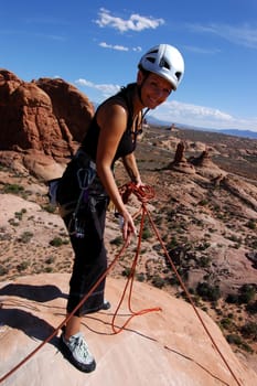 Female rock climber on top of desert tower
