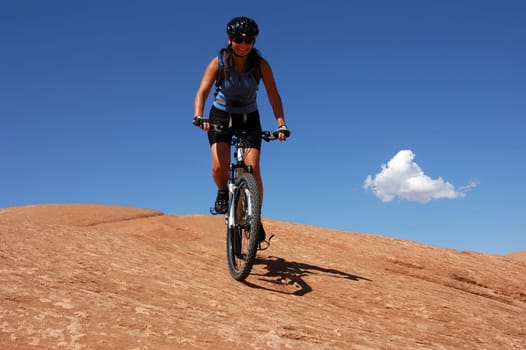 Woman biking on slick rock in Moab, Utah
