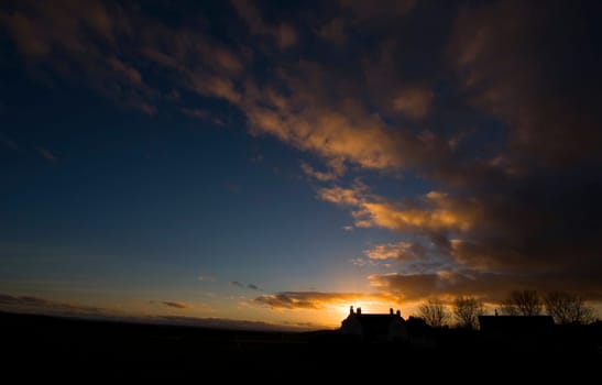 Sun setting behind a cottage in Gullane, east of Edinburgh