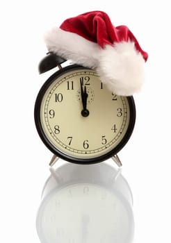 Black alarm clock in a New Year's cap on a white background