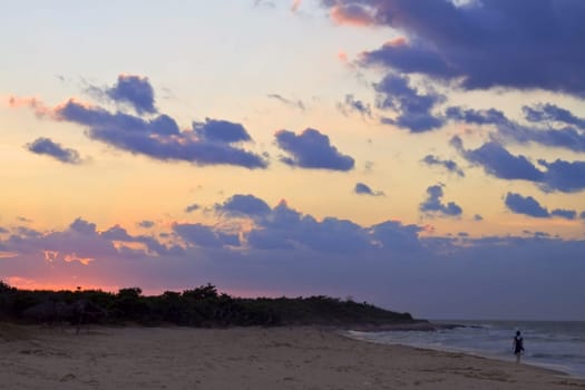 Tropical holidays sunset & beach. Signe woman walking on a beach