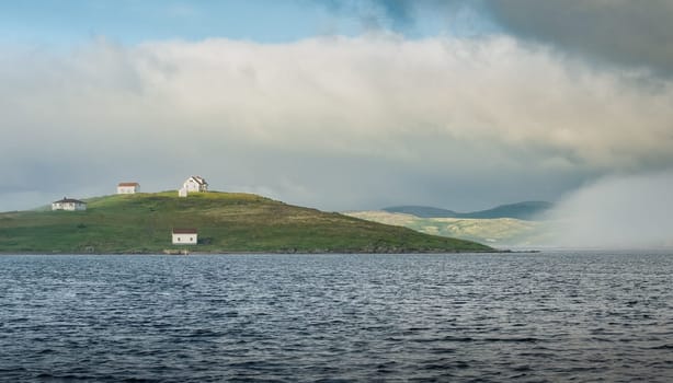 Small fishing buildings bathed in the mist in Labrador