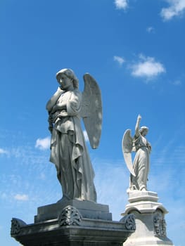 detail of winged angel statue against blue sky