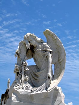 detail of winged angel statue against blue sky