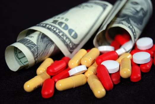 Pills falling out of American bills.