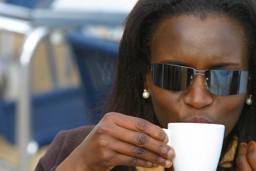 A young African American woman drinking coffee