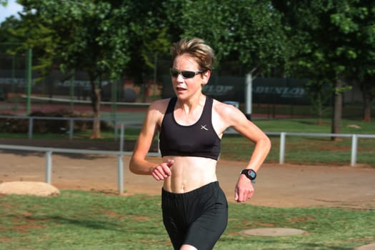 Female marathon champion training in the park.