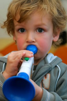A young boy playing a toy trumpet