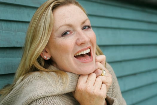 An attractive woman in her thirties laughing outside
