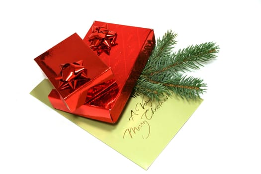 Two red gift boxes with Christmas postal card and branch of fir-tree