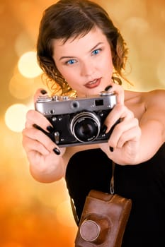 a glamorous girl in the evening dress holding a camera