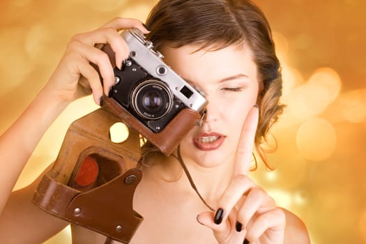 a glamorous girl in the evening dress holding a camera