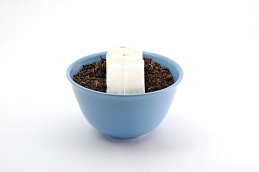 Tea leafs and bags in blue bowl