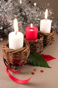 3 candles with christmas ornaments