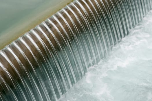 Soft image of water flowing over a dam