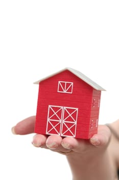 The red house is in a female hand on a white background