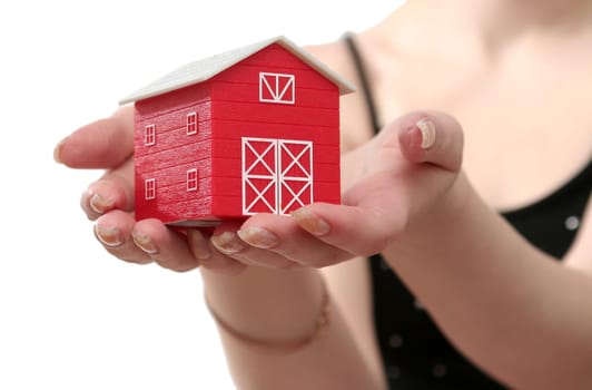 The red house is in a female hand on a white background