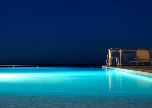 a still illuminated infinity swimming pool at night