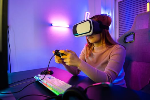 Excited woman virtual playing gamepad controller she very determined at home, Gamer in VR headset glasses exploring metaverse play video game online with joystick on computer neon lights
