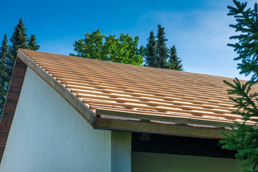 View of a roof prepared for shingles with counter battens against a blue sky.