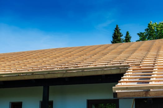 View of a roof prepared for shingles with counter battens against a blue sky.