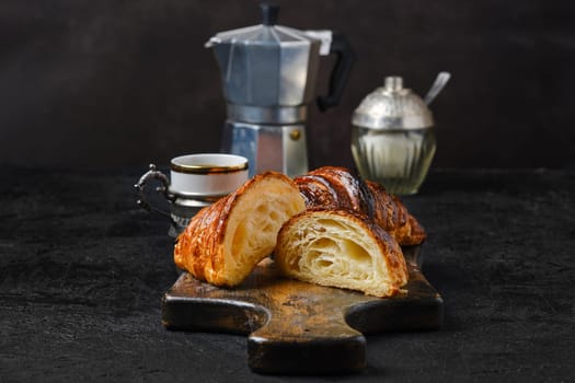 Classic breakfast with croissant cut on half and espresso coffee