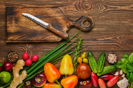 Top view of wooden table with different vegetables for salad. Healthy eating concept.