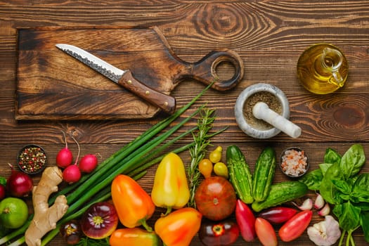 Top view of wooden table with different vegetables for salad. Healthy eating concept.