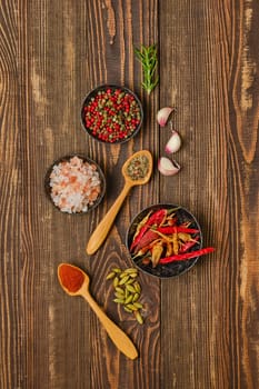 Overhead composition with spicy spice and seasonings on wooden background