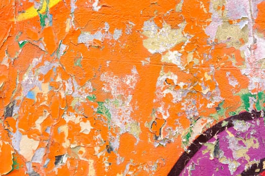 Colorful wall background with damaged paints of orange.
