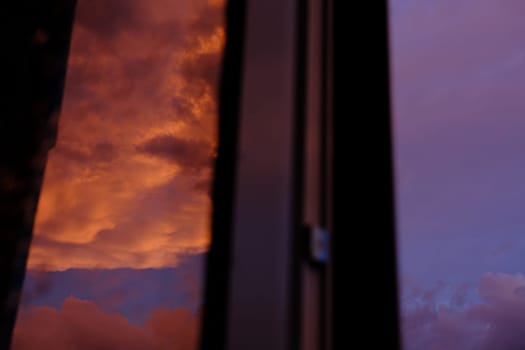 Dawn sky with colorfull clouds. Sunset landscape through the window with reflection on it.