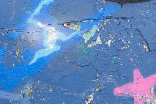 Colorful wall background with damaged paints of blue.