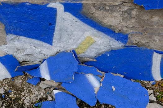 Colorful wall background with damaged paints of blue.