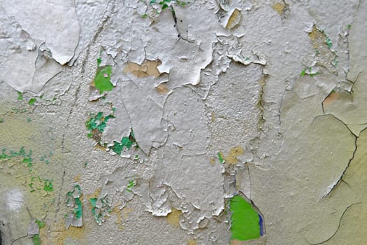 Colorful wall background with damaged paints of gray silver and green.