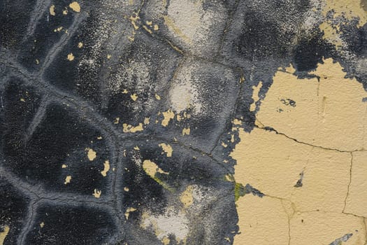 Colorful wall background with damaged paints of blue and biege.
