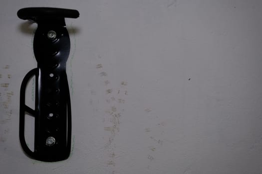 Bicycle tire hook clamp on the wall.