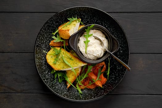 Top view of crispy toasted garlic bread with sour curd and braised tomato