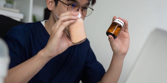A medical student closely examines two medication bottles during an online study session, highlighting attention to detail in healthcare education.