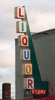 Vertical Liquor Store Sign Brick Wall Outside Advertisement