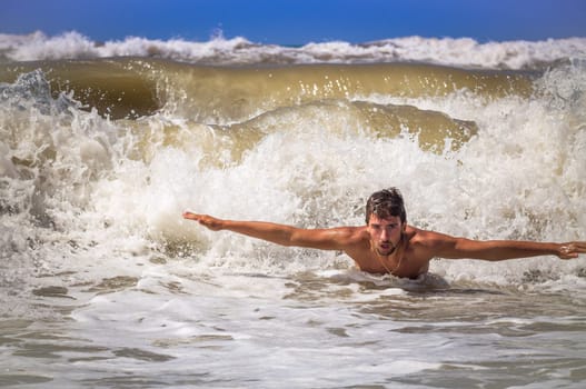 A boy taking a bath in seaside with agitated sea