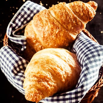 Close up Tasty Fresh Homemade Croissant Bread on Basket with Checkered Cloth, Placed on top of the Table.