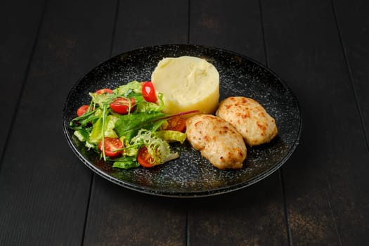 Meat cutlet with mashed potato and fresh vegetables on a plate