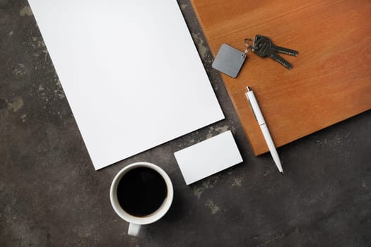 Branding stationery mockup, key and coffee cup on concrete background. Flat lay.